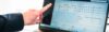 Eine Person zeigt mit dem Finger auf Kennzahlen, die auf einem Laptop zu sehen sind